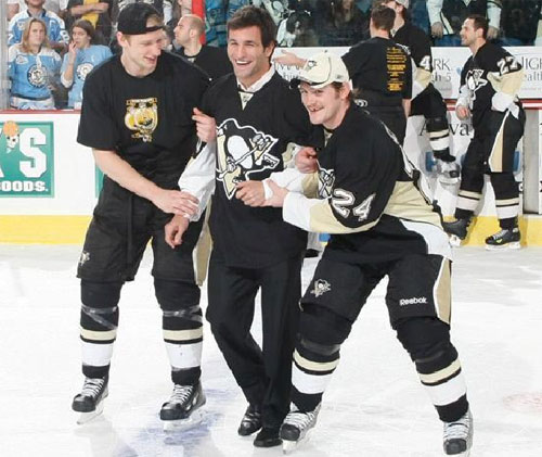 Jordan Staal and Matt Cooke help Mike Zigomanis to center ice for Shirts off out Backs night.