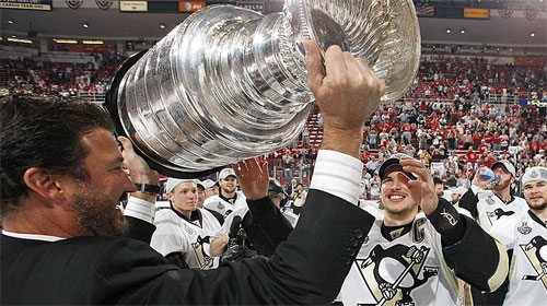 Mario Lemieux passes the Stanley Cup onto Sidney Crosby