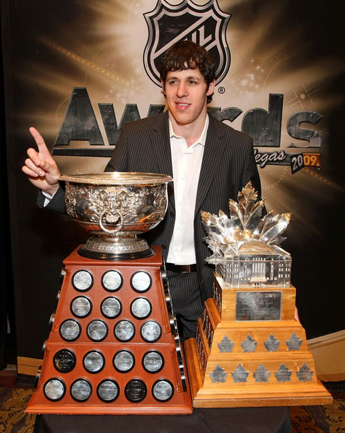 Evgeni Malkin poses with the Art Ross and Conn Smythe trophies